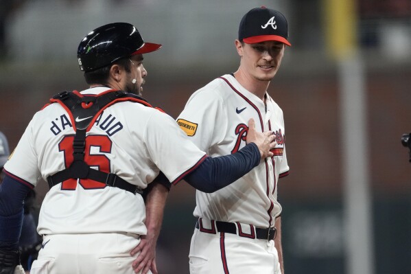 Atlanta Braves pitcher Max Fried (54) and catcher Travis d'Arnaud (16) leave the field after defeating the Miami Marlins in a baseball game Tuesday, April 23, 2024, in Atlanta. (AP Photo/John Bazemore)