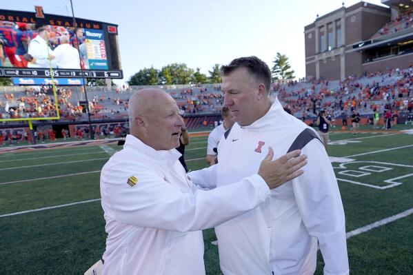 Wyoming head coach Craig Bohl, left, and Illinois head coach Brent Bielema talk after Illinois defeated Wyoming in an NCAA college football game Saturday, Aug. 27, 2022, in Champaign, Ill. (AP Photo/Charles Rex Arbogast)