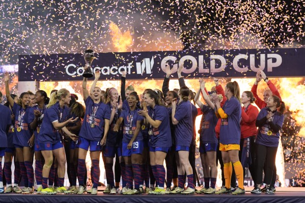 United States' Alex Morgan holds the trophy alongside teammates after the United States defeated Brazil in the CONCACAF Gold Cup women's soccer tournament final match, Sunday, March 10, 2024, in San Diego. (AP Photo/Gregory Bull)