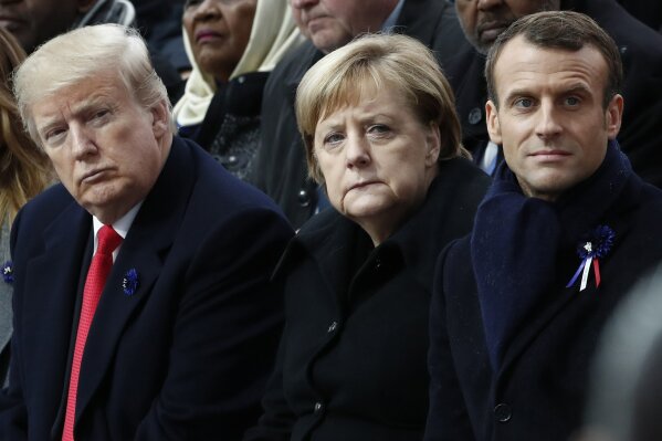 FILE - In this Nov.11, 2018 file photo, French President Emmanuel Macron, German Chancellor Angela Merkel and President Donald Trump attend a commemoration ceremony for Armistice Day, 100 years after the end of the First World War at the Arc de Triomphe in Paris, France. World leaders including Merkel and Macron are condemning the storming of the U.S. Capitol by supporters of President Donald Trump. (Benoit Tessier/Pool Photo via AP)