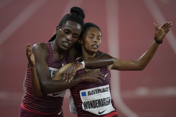 FILE - Workua Getachew of Ethiopia, left, winner of the women's 3000m steeplechase final hugs the second-placed Zerfe Wondemagegn, also of Ethiopia, during the Diamond League athletics meeting at the Louis II stadium in Monaco, Wednesday, Aug. 10, 2022. Wondemagegn, who reached the 3,000-meter steeplechase final at the Tokyo Olympics, and narrowly missed the world championship podium last year, has been banned for five years for doping after testing positive for two banned substances. Wondemagegn admitted breaking anti-doping rules after samples she gave flagged up traces of testosterone and another substance, EPO, which can help athletes' blood transport more oxygen, an Athletics Integrity Unit ruling published Monday, April 22, 2024, said. (AP Photo/Daniel Cole, file)