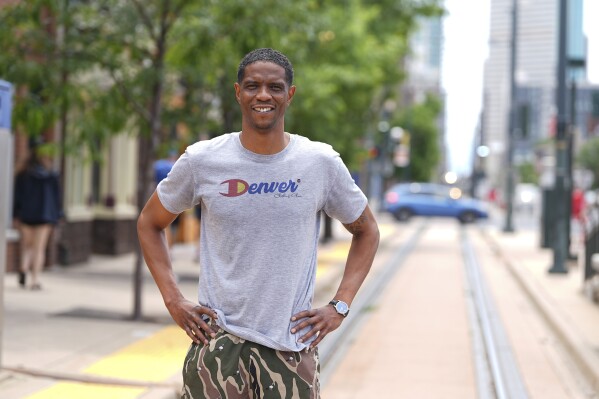 Norman Harris, executive director of JMF Corporation that puts on a Juneteenth celebration in Denver, is shown on the light-rail track running through the neighborhood where the event is staged Friday, June 13, 2025, in Denver. (AP Photo/David Zalubowski)