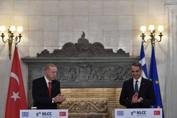 Greece's Prime Minister Kyriakos Mitsotakis, right, and Turkey's President Recep Tayyip Erdogan applaud after their statements at Maximos Mansion in Athens, Greece, Thursday, Dec. 7, 2023. Turkish President Recep Tayyip Erdogan is visiting Greece in an effort to mend strained relations and reset ties with Western allies. (AP Photo/Michael Varaklas)
