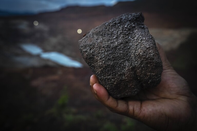 A mining engineer shows a piece of chromium ore at a mine near Kaliapani village in Jajpur district, Odisha, India on Wednesday, July 5, 2023. (AP Photo/Anupam Nath)