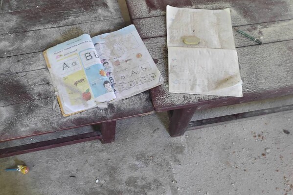 FILE - An alphabet book and a notebook lie on top of an elevated wooden floorboard of a middle school in Let Yet Kone village in Tabayin township in the Sagaing region of Myanmar on Sept. 17, 2022, the day after an air strike hit the school. A group of human rights researchers officially launched a website Wednesday, Nov. 1, 2023 that they hope will help get justice for victims of state violence in Myanmar, where one of the world’s less-noticed but still brutal armed struggles is taking place. (AP Photo, File)