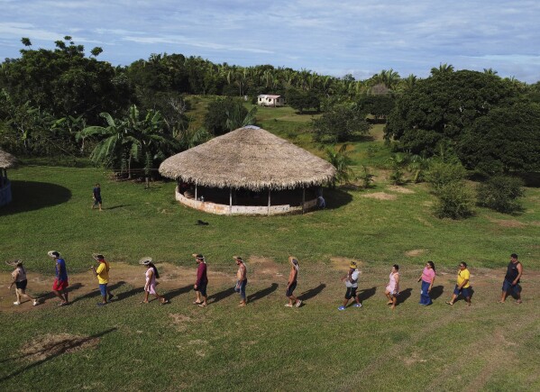 Members of the Mura Indigenous community walk to participate in a gathering of leaders, in the Moyray village, in Autazes, Amazonas state, Brazil, Friday, Feb. 21, 2025. (AP Photo/Edmar Barros)