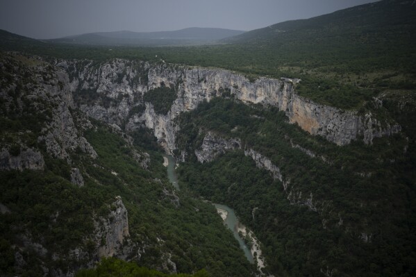 The Verdon River snakes through a gorge in southern France, Monday, June 19, 2023. Human-caused climate change is lengthening droughts in southern France, meaning the reservoirs are increasingly drained to lower levels to maintain the power generation and water supply needed for nearby towns and cities. (AP Photo/Daniel Cole)