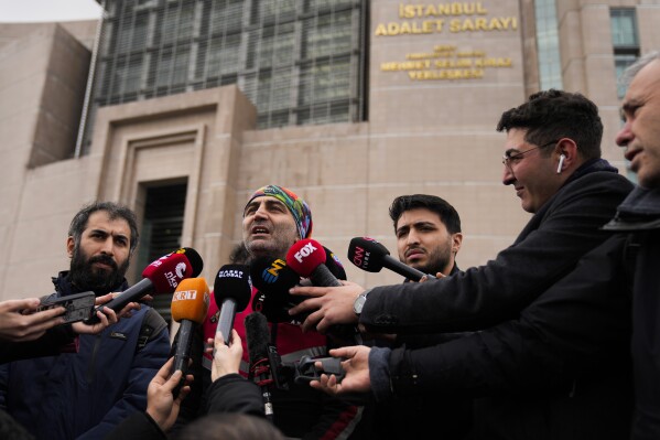 Mesut Ceki, center, a courier rights association member and colleague of Turkish motorcycle courier Yunus Emre Gocer, talks to journalist outside the Justice court in Istanbul, Turkey, Tuesday, Jan. 16, 2024. A court in Istanbul on Tuesday convicted the son of Somalia's president over the death of a motorcycle courier and sentenced him to two years and six months in prison. The sentence, however, was immediately commuted to a fine. (AP Photo/Francisco Seco)