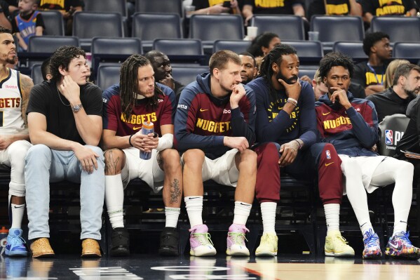 Denver Nuggets' Nikola Jokic, center, and the rest of the bench watch play against the Oklahoma City Thunder late in the second half of Game 2 in the conference semifinals of the NBA basketball playoffs, Wednesday, May 7, 2025, in Oklahoma City. (AP Photo/Kyle Phillips)