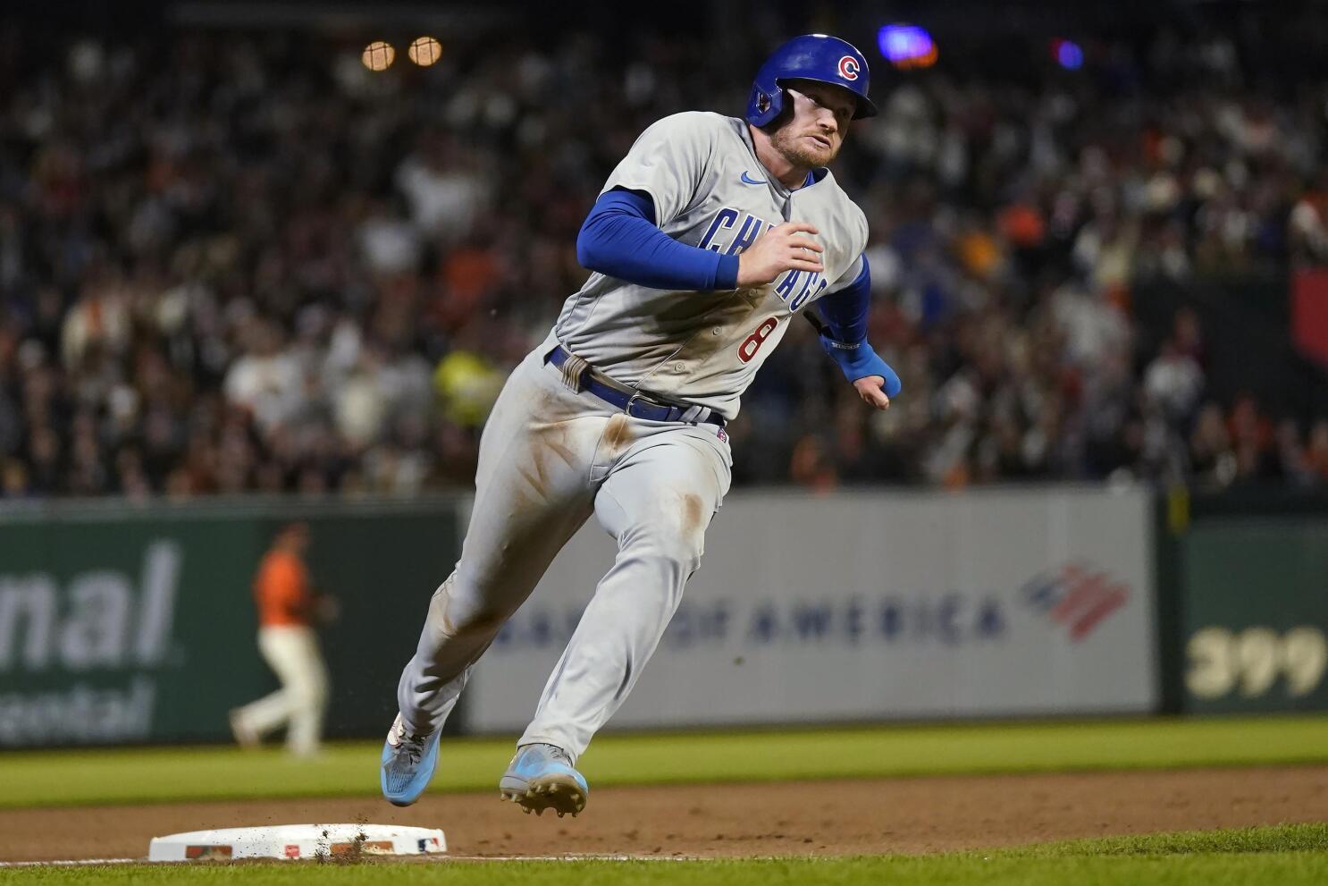 Chicago Cubs' Seiya Suzuki, left, is congratulated by first base coach Mike  Napoli after hitting a single against the San Francisco Giants during the  eighth inning of a baseball game in San