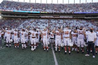 FILE - In this Saturday, Oct. 24, 2020, file photo, Texas players, including Sam Ehlinger (11), sing "The Eyes Of Texas" after an NCAA college football game against Baylor in Austin, Texas. The University of Texas marching band and pep band will be required to play “The Eyes of Texas” school song when they return to performing, but the school will also create a new band that doesn't include it in its play list, the school has announced. The song has been mired in controversy since summer 2020 when a group of athletes and students called on the school to ditch the tune amid national racial injustice protests after the killing of George Floyd. (AP Photo/Chuck Burton, File)