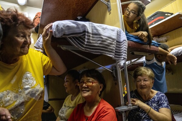 People travel in a train compartment on the way to Aralsk, Kazakhstan, Friday, June 30, 2023. (AP Photo/Ebrahim Noroozi)