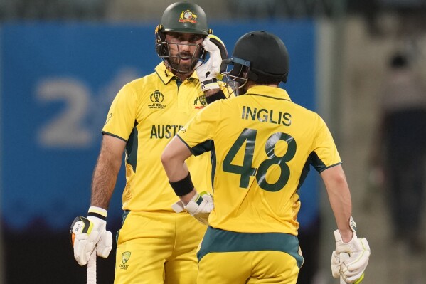 Australia's Glenn Maxwell talks to Josh Inglis after hitting a boundary during the ICC Men's Cricket World Cup match between Australia and Sri Lanka in Lucknow, India, Monday, Oct. 16, 2023. (AP Photo/Aijaz Rahi)