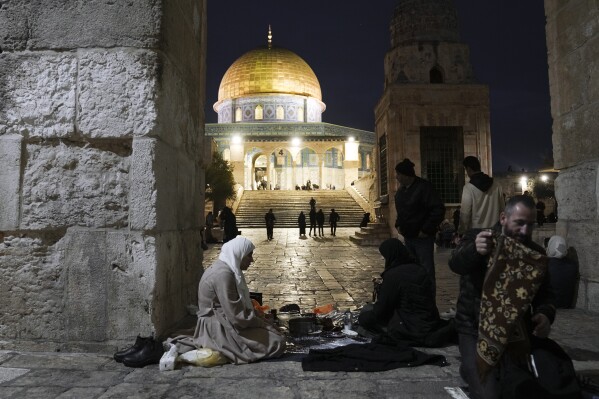Palestinian Muslims break their fast during the Muslim holy month of Ramadan outside the Dome of Rock at the Al-Aqsa Mosque compound in the Old City of Jerusalem, Saturday, March 16, 2024. (AP Photo/Mahmoud Illean)