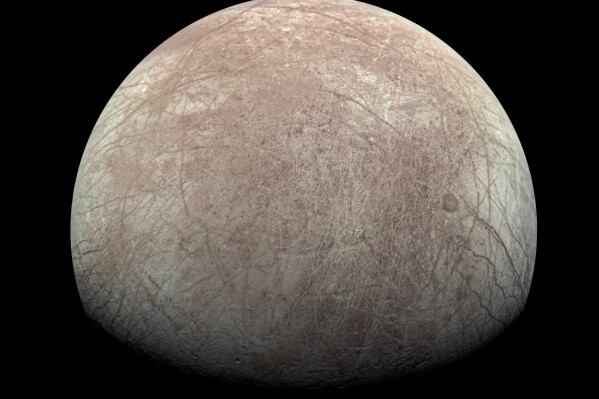 This image provided by NASA, processed by Kevin M. Gill, shows Jupiter's moon Europa captured by the Juno spacecraft on Sept. 29, 2022, with north to the left. Research published Monday, March 4, 2024, suggests there's less oxygen on the icy surface of Jupiter's moon Europa than thought — and that could affect what if any life might be lurking in the moon’s underground ocean. (Kevin M. Gill/NASA/JPL-Caltech/SwRI via AP)