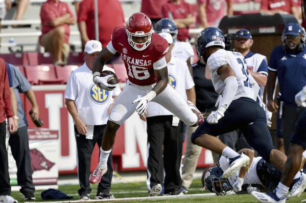Arkansas receiver Treylon Burks (16) is knocked out of bounds by Rice defenders after making a catch during the second half of an NCAA college football game Saturday, Sept. 4, 2021, in Fayetteville, Ark. (AP Photo/Michael Woods)