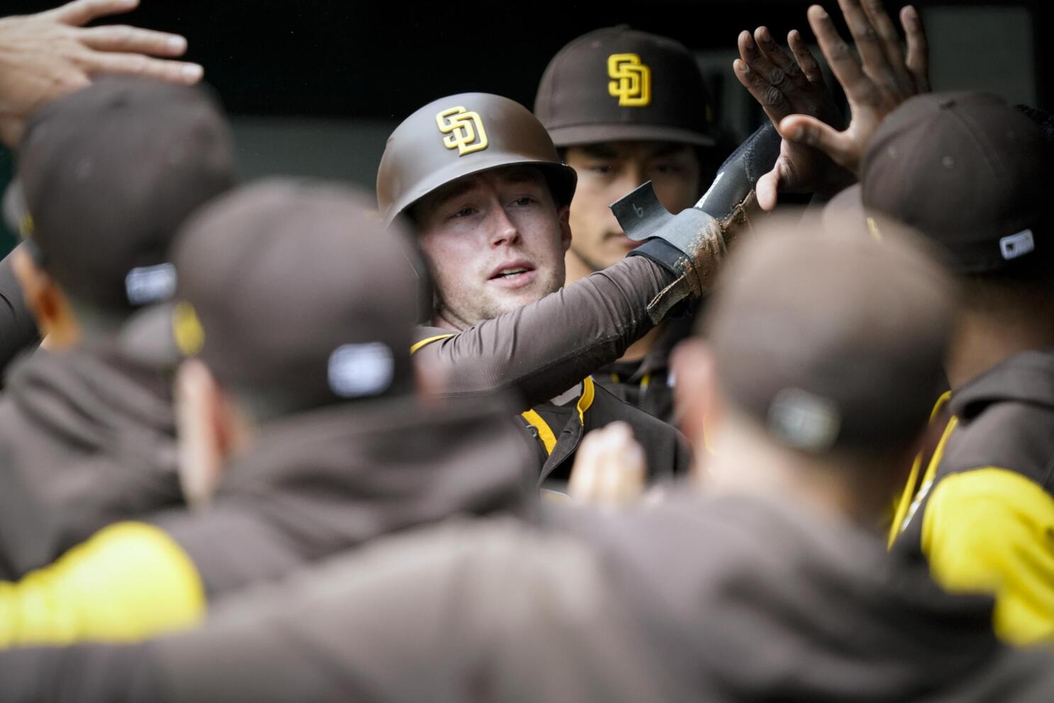 San Diego Padres' Brandon Drury, center, talks with trainers and manager  Bob Melvin (3) after being hit in the helmet by a pitch during the fourth  inning of a baseball game against