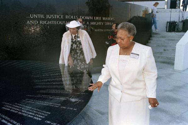 FILE - Mamie Till-Mobley, mother of lynching victim Emmett Till, right, and Wilma Allen, of New Orleans, search for their relatives' names on the black granite table at the Civil Rights Memorial in Montgomery, Ala., Nov. 5, 1989. A memorial honoring Till-Mobley will be unveiled Saturday, April 29, 2023, outside the suburban Chicago high school she attended as a young woman, long before she became a critical player in the Civil Rights Movement. (AP Photo/Dave Martin, File)