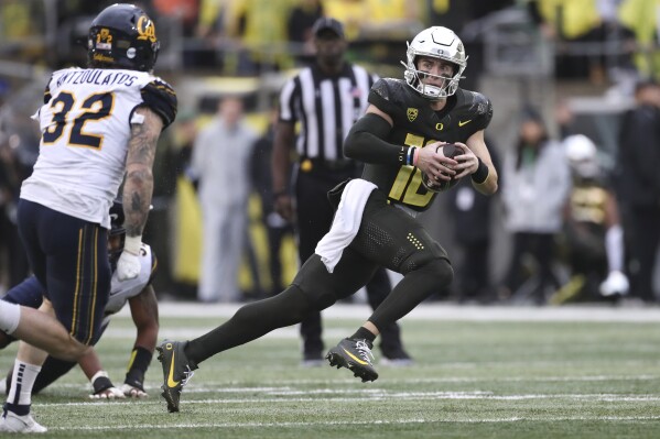 Oregon quarterback Bo Nix (10) dodges California linebacker Blake Antzoulatos (32) during the first half of an NCAA football game, Saturday, Nov. 4, 2023, in Eugene, Ore. (AP Photo/Amanda Loman)