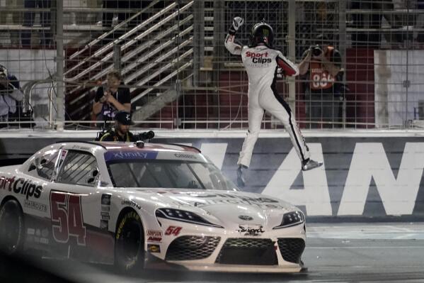 Ty Gibbs leaps off his car as he celebrates his win in the NASCAR Xfinity Series auto race at Atlanta Motor Speedway in Hampton, Ga., Saturday, March 19, 2022. (AP Photo/John Bazemore)