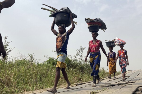 FILE - Women and children return from their farmlands after the day's work in Agatu village on the outskirts of Benue State in Nigeria, Wednesday, Jan 5, 2022. Nigeria’s statistics agency on Thursday, Aug. 24, 2023, reported the country’s unemployment rate as 4.1%, the lowest in many years, but one which analysts said was an undercount because of the agency's new methodology. In its new labor force report, the bureau said about three in four working-age Nigerians aged at least 15 were employed in the first quarter of 2023. (AP Photo/ Chinedu Asadu)