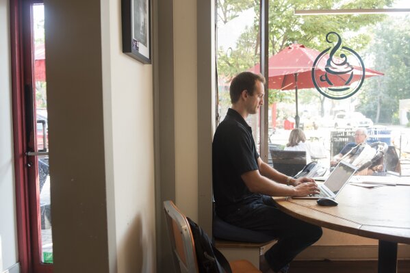 
              Tom Szold, Chief Executive Officer at Precision Safe Sidewalks, works from a coffee shop on Friday, July 27, 2018, in Alexandria, Va. Szold joined his brother and a longtime friend in May to buy Precision Safe Sidewalks, which helps city governments and other customers identify where their trip hazards are and how to fix them. (AP Photo/Kevin Wolf)
            