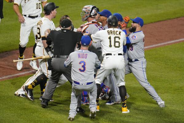 Pittsburgh Pirates' John Nogowski, left, and New York Mets starting pitcher Marcus Stroman, fourth from right, exchange words as players and coaches arrive during the sixth inning of a baseball game Friday, July 16, 2021 in Pittsburgh. (AP Photo/Gene J. Puskar)