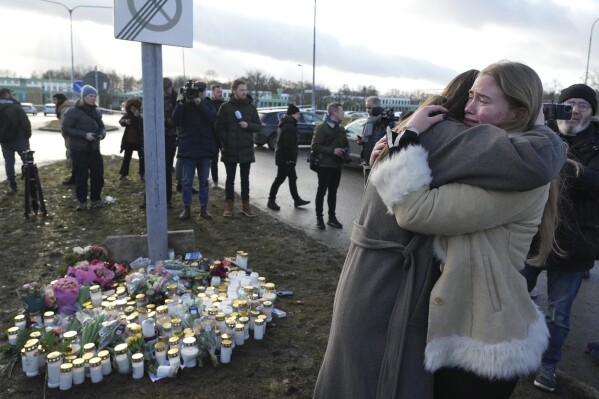 People gather at a memorial near the scene of the shooting in the outskirts of Orebro, Sweden on Wednesday, February 5th, 2025 (AP Photo/Sergei Grits)