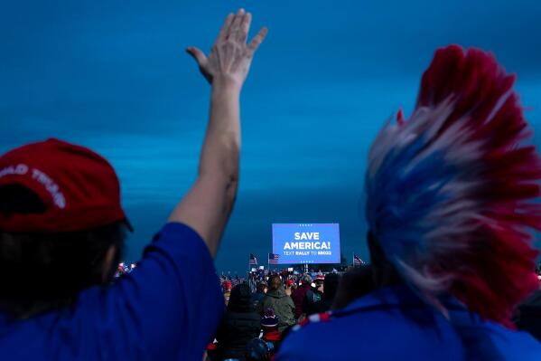 A supporter raises her hand in prayer while listening to a speaker at a rally for former President Donald Trump on Saturday, Jan. 15, 2022, in Florence, Az. (AP Photo/Nathan Howard)
