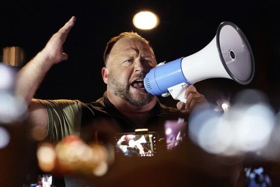 FILE - Infowars host and conspiracy theorist Alex Jones rallies pro-Trump supporters, Nov. 5, 2020, in Phoenix. Jones' latest bankruptcy plan would pay Sandy Hook families a minimum total of $55 million over 10 years, a fraction of the $1.5 billion awarded to the relatives in lawsuits against Jones for calling the 2012 Newtown school shooting a hoax.(AP Photo/Matt York, File)