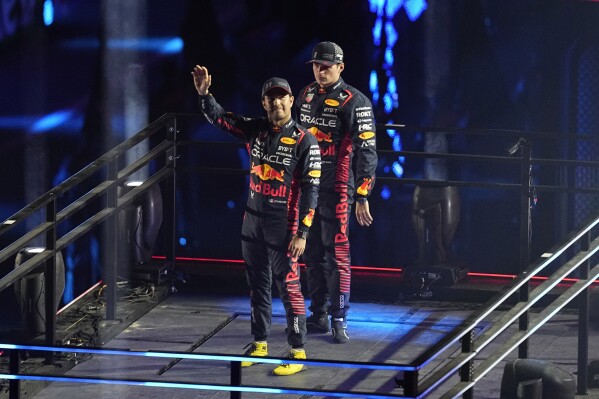 Red Bull driver Sergio Perez, of Mexico, left, and Red Bull driver Max Verstappen, of the Netherlands, motion during an opening ceremony for the Formula One Las Vegas Grand Prix auto race, Wednesday, Nov. 15, 2023, in Las Vegas. (AP Photo/Darron Cummings)