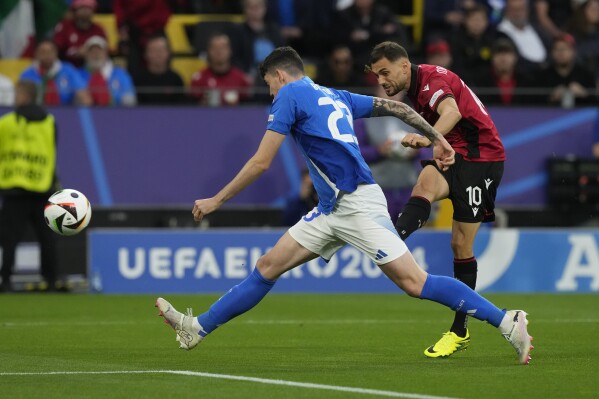 Albania's Nedim Bajrami, back, scores his side's opening goal during a Group B match between Italy and Albania at the Euro 2024 soccer tournament in Dortmund, Germany, Saturday, June 15, 2024. (AP Photo/Frank Augstein)