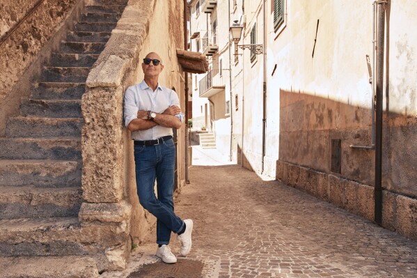 This image released by National Geographic shows Stanley Tucci posing in the Abruzzo region of Italy during the filming of his series "Tucci in Italy." (Matt Holyoak/National Geographic via AP)