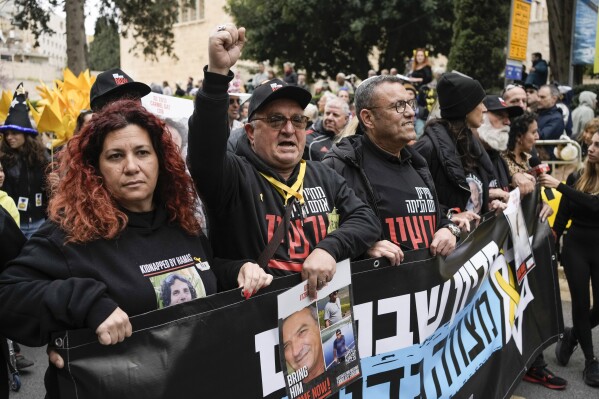 Relatives and supporters of the Israeli hostages held in the Gaza Strip by the Hamas militant group leads the Purim parade in Jerusalem, Monday, March 25, 2024. For the first time after 42 years and amid the Israel-Hamas war, Jerusalem holds a Purim parade on Monday. (AP Photo/Leo Correa)