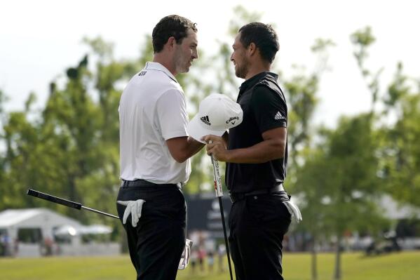 Patrick Cantlay and his teammate Xander Schauffele, right, congratulate each other after their win in the PGA Zurich Classic golf tournament at TPC Louisiana in Avondale, La., Sunday, April 24, 2022. (AP Photo/Gerald Herbert)