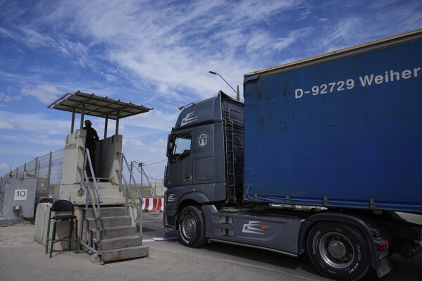 FILE - A truck carrying humanitarian aid for the Gaza Strip passes through the Kerem Shalom Crossing in southern Israel, Thursday, March 14, 2024. Under heavy U.S. pressure, Israel has promised to ramp up aid to Gaza dramatically, saying last week it would open another cargo crossing and surge more trucks than ever before into the besieged enclave. But days later, there are few signs of those promises materializing and international officials say famine is fast approaching in hard-hit northern Gaza. (AP Photo/Ohad Zwigenberg, File)