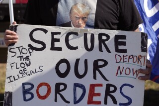 FILE - Phill Cady holds a sign during a "Take Our Border Back" rally on Feb. 3, 2024, in Quemado, Texas. Online actors tied to the Kremlin have begun pushing misleading and incendiary claims about U.S. immigration in an apparent bid to target American voters ahead of the 2024 election. (AP Photo/Eric Gay)