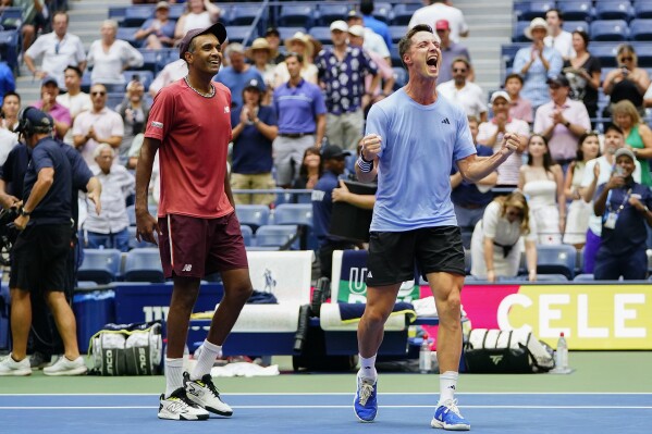 Joe Salisbury, of Great Britain, right, and Rajeev Ram, of the United States, react after defeating Rohan Bopanna, of India, and Matthew Ebden, of Australia, during the men's doubles final of the U.S. Open tennis championships, Friday, Sept. 8, 2023, in New York. (AP Photo/Frank Franklin II)