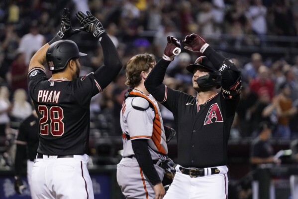 Arizona Diamondbacks' Christian Walker, right, celebrates with teammate Tommy Pham (28) after hitting a two-run home run against the Baltimore Orioles during the sixth inning of a baseball game Friday, Sept. 1, 2023, in Phoenix. (AP Photo/Ross D. Franklin)