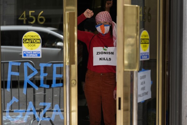 Pro-Palestinian demonstrators raise their fists while occupying the lobby of a building housing the Israeli Consulate in San Francisco, Monday, June 3, 2024. (AP Photo/Jeff Chiu)