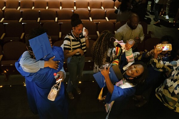A graduate receives a hug after the Senior Salute at Lyric Theatre in Lexington, Kentucky, Wednesday, May 7, 2025. (AP Photo/Jon Cherry)