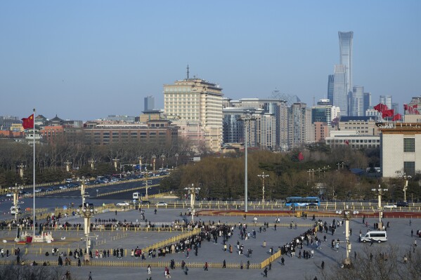 Visitors tour Tiananmen Square as high-rise office buildings of Central Business District are seen in the background, in Beijing, Wednesday, March 6, 2024. China has plenty of room to maneuver to attain its target for robust economic growth of about 5% this year, top Chinese financial officials said Wednesday, after a strong start for the year. (AP Photo/Andy Wong)
