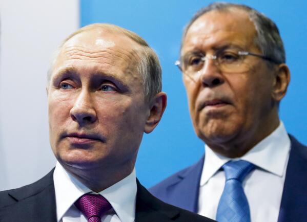 FILE - Russian President Vladimir Putin, left, and Foreign Minister Sergey Lavrov stand while waiting for Turkish President Recep Tayyip Erdogan prior to their talks at the G-20 summit in Hamburg, northern Germany,  July 8, 2017. In his role for nearly 18 years, Lavrov, 71, has seen relations with the West shift from near-friendly to openly hostile, plummeting to a catastrophic new low with the Russian war against Ukraine. The invasion prompted the European Union to freeze the assets of both Putin and Lavrov, among others — an unprecedented blow to Moscow's pride. (AP Photo/Alexander Zemlianichenko, File)