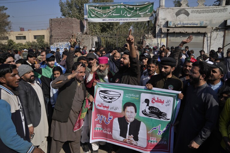 Supporters of imprisoned Pakistan's Former Prime Minister Imran Khan's party block a road as a protest against the delaying result of parliamentary election by Pakistan Election Commission, in Lahore, Pakistan, Friday, Feb. 9, 20204. (AP Photo/K.M. Chaudary)