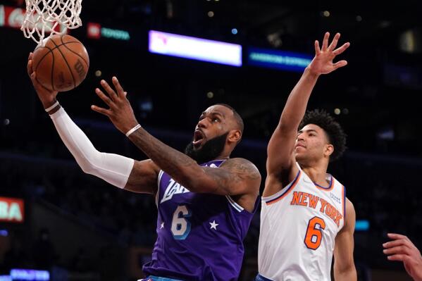 Los Angeles Lakers forward LeBron Jame, left, shoots as New York Knicks guard Quentin Grimes defends during the first half of an NBA basketball game Saturday, Feb. 5, 2022, in Los Angeles. (AP Photo/Mark J. Terrill)
