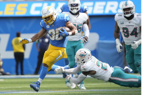 Los Angeles Chargers running back Austin Ekeler (30) runs past Miami Dolphins safety DeShon Elliott during the first half of an NFL football game Sunday, Sept. 10, 2023, in Inglewood, Calif. (AP Photo/Mark J. Terrill)