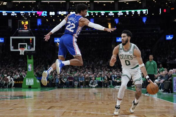 Boston Celtics forward Jayson Tatum (0) dribbles around Philadelphia 76ers guard Matisse Thybulle (22) after faking a shot during the second half of an NBA basketball game, Wednesday, Feb. 8, 2023, in Boston. (AP Photo/Charles Krupa)