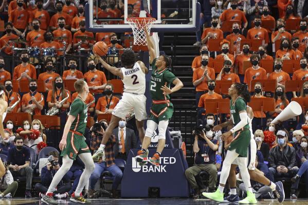 Virginia guard Reece Beekman (2) shoots as Miami guard Isaiah Wong (2) defends during an NCAA college basketball game in Charlottesville, Va., Saturday, Feb. 5, 2022. (AP Photo/Andrew Shurtleff)