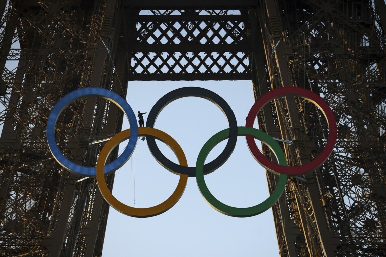 The Olympic rings are mounted on the Eiffel Tower Friday, June 7, 2024 in Paris. The Paris Olympics organizers mounted the rings on the Eiffel Tower on Friday as the French capital marks 50 days until the start of the Summer Games. The 95-foot-long and 43-foot-high structure of five rings, made entirely of recycled French steel, will be displayed on the south side of the 135-year-old historic landmark in central Paris, overlooking the Seine River. (AP Photo//Thomas Padilla)