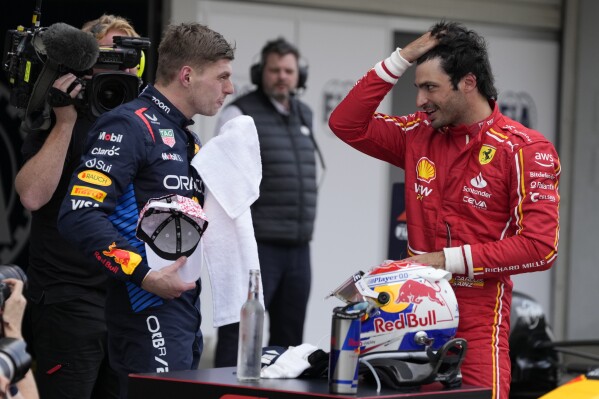 Red Bull driver Max Verstappen of the Netherlands, left, Ferrari driver Carlos Sainz of Spain, right, speak after the Japanese Formula One Grand Prix at the Suzuka Circuit in Suzuka, central Japan, Sunday, April 7, 2024. (AP Photo/Hiro Komae)